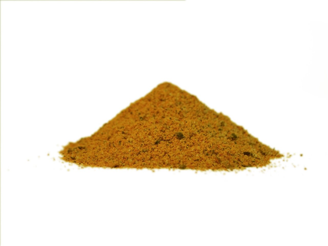 Vista frontal a nivel de superficie de un pequeño montón cónico de especias finamente molidas de color amarillo o mostaza